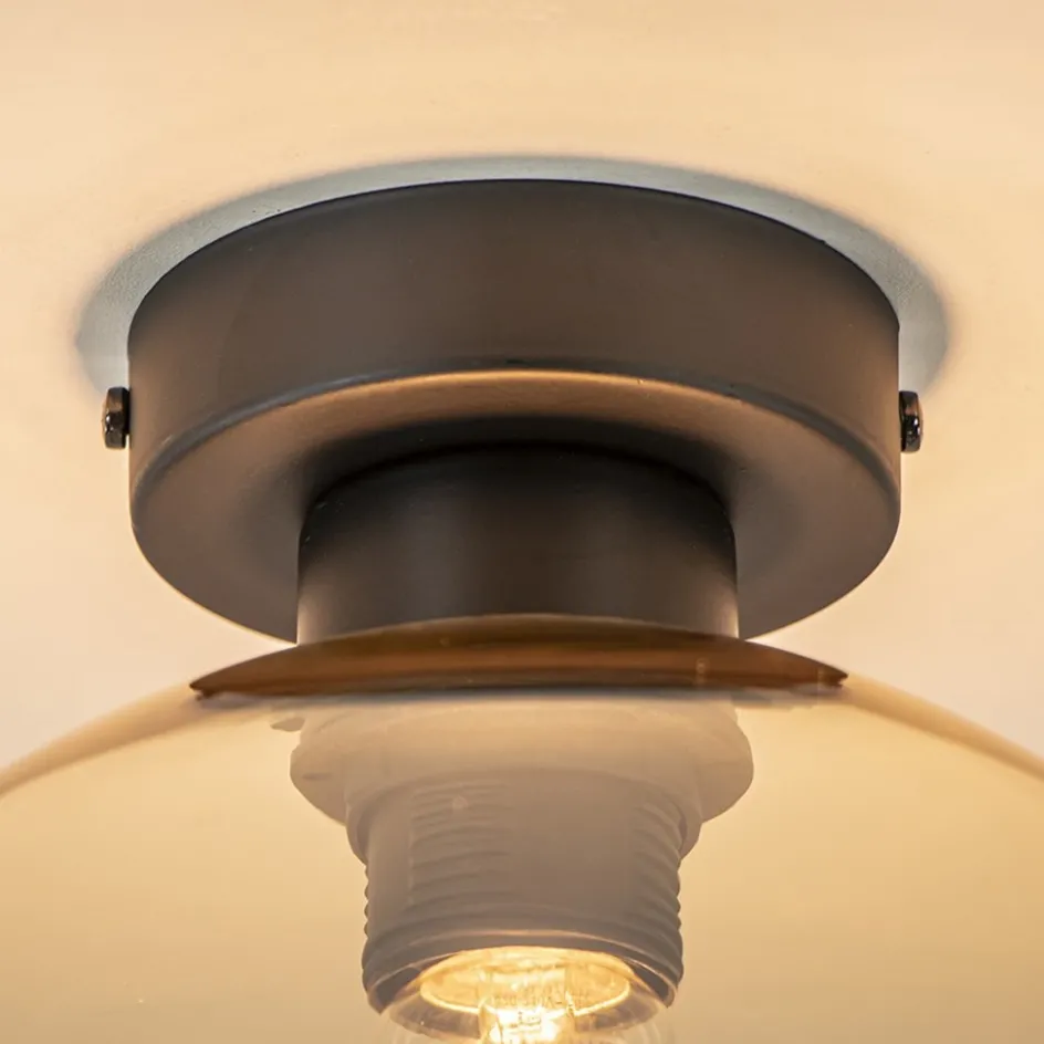 Mat zwarte plafondlamp met amber glazen bol>Straluma Online